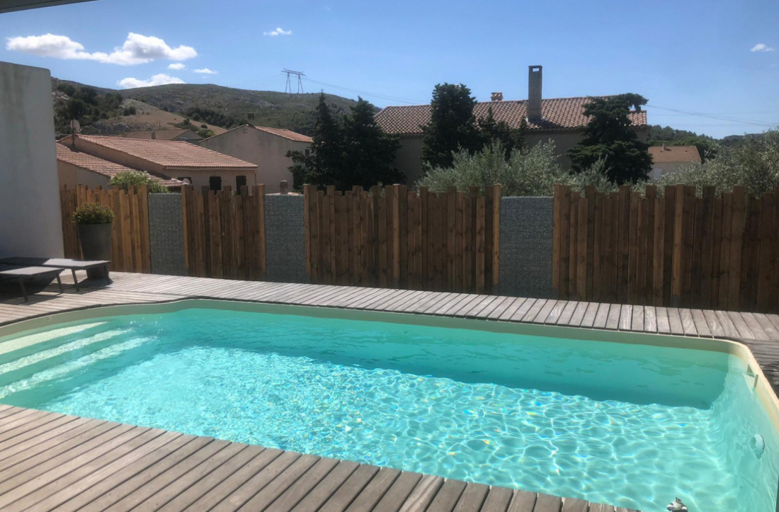 Piscine bord&eacute;e d'un cl&ocirc;ture esth&eacute;tique la mettant en valeur