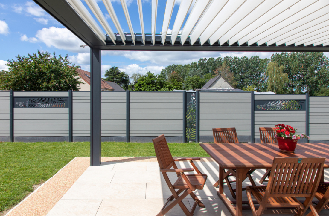 Clôture composite avec décor, harmonisée avec la pergola